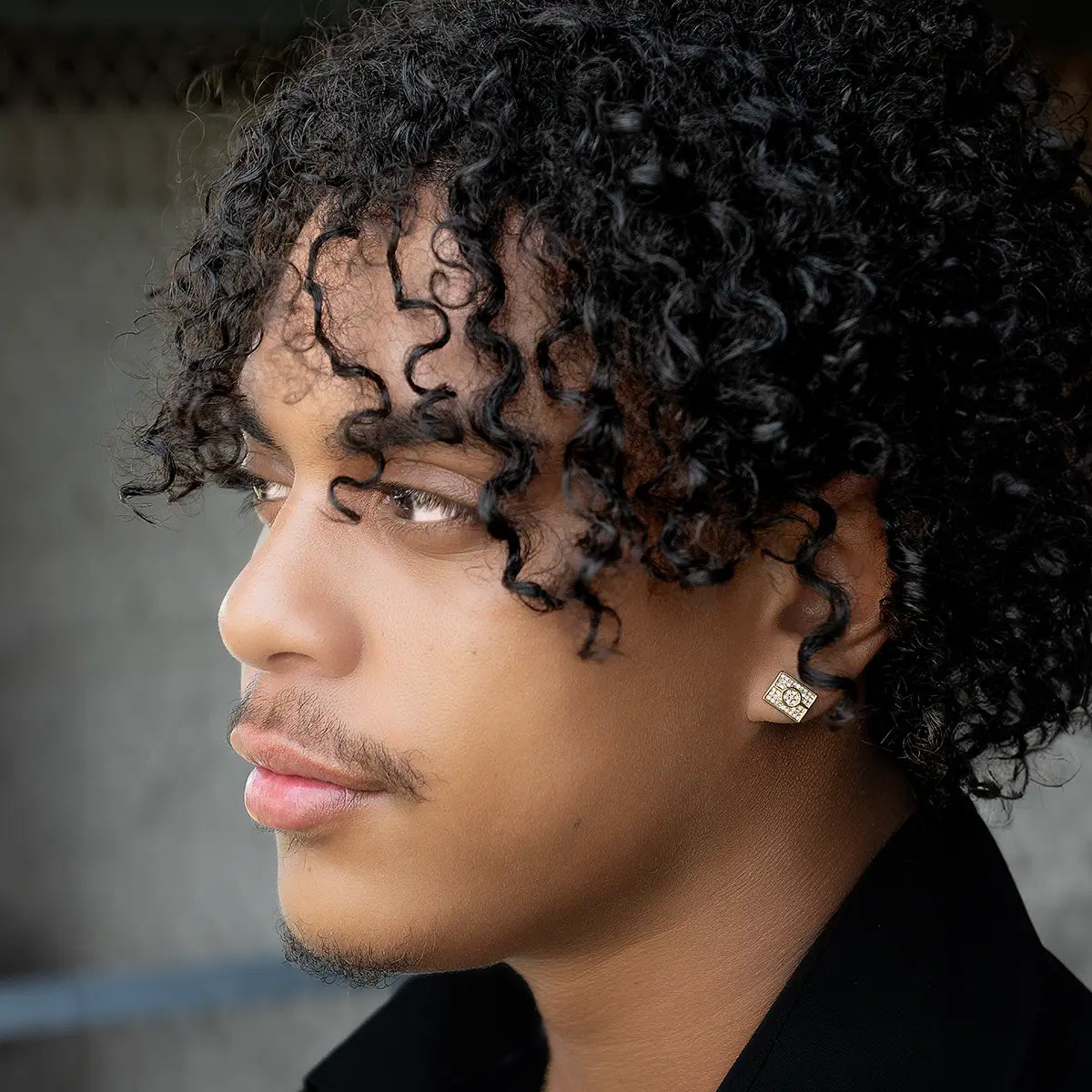 Profile of a man wearing Aboriginal Flag Earrings with gold and crystals in the shape of the Aboriginal Flag